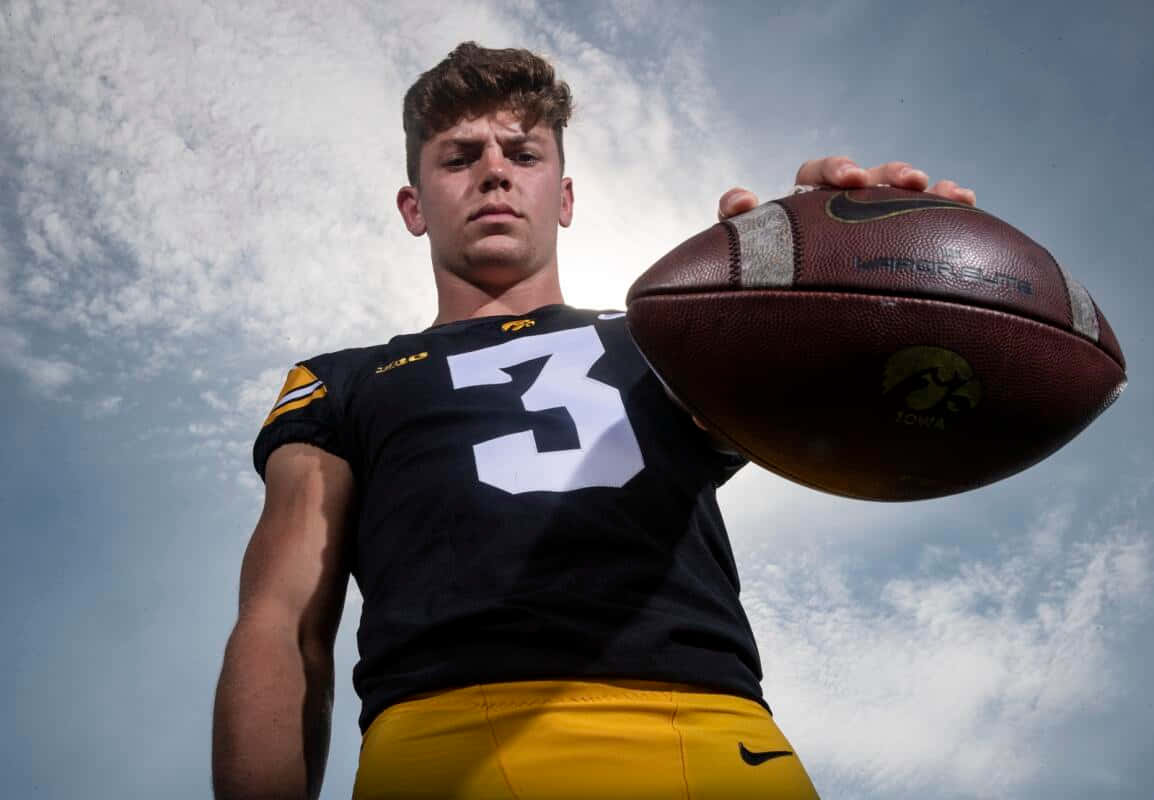 Football Player Holding Ball Against Sky Wallpaper