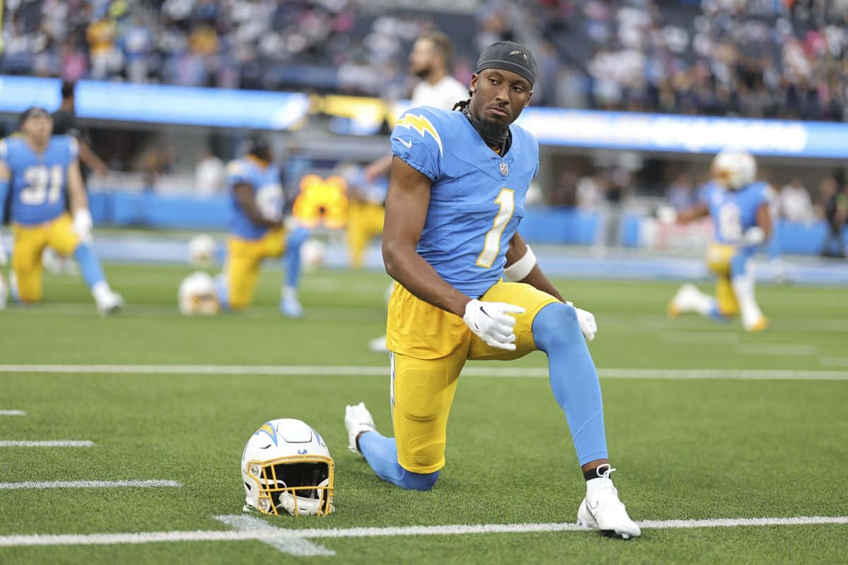 Football Player Kneeling Beside Helmet Wallpaper