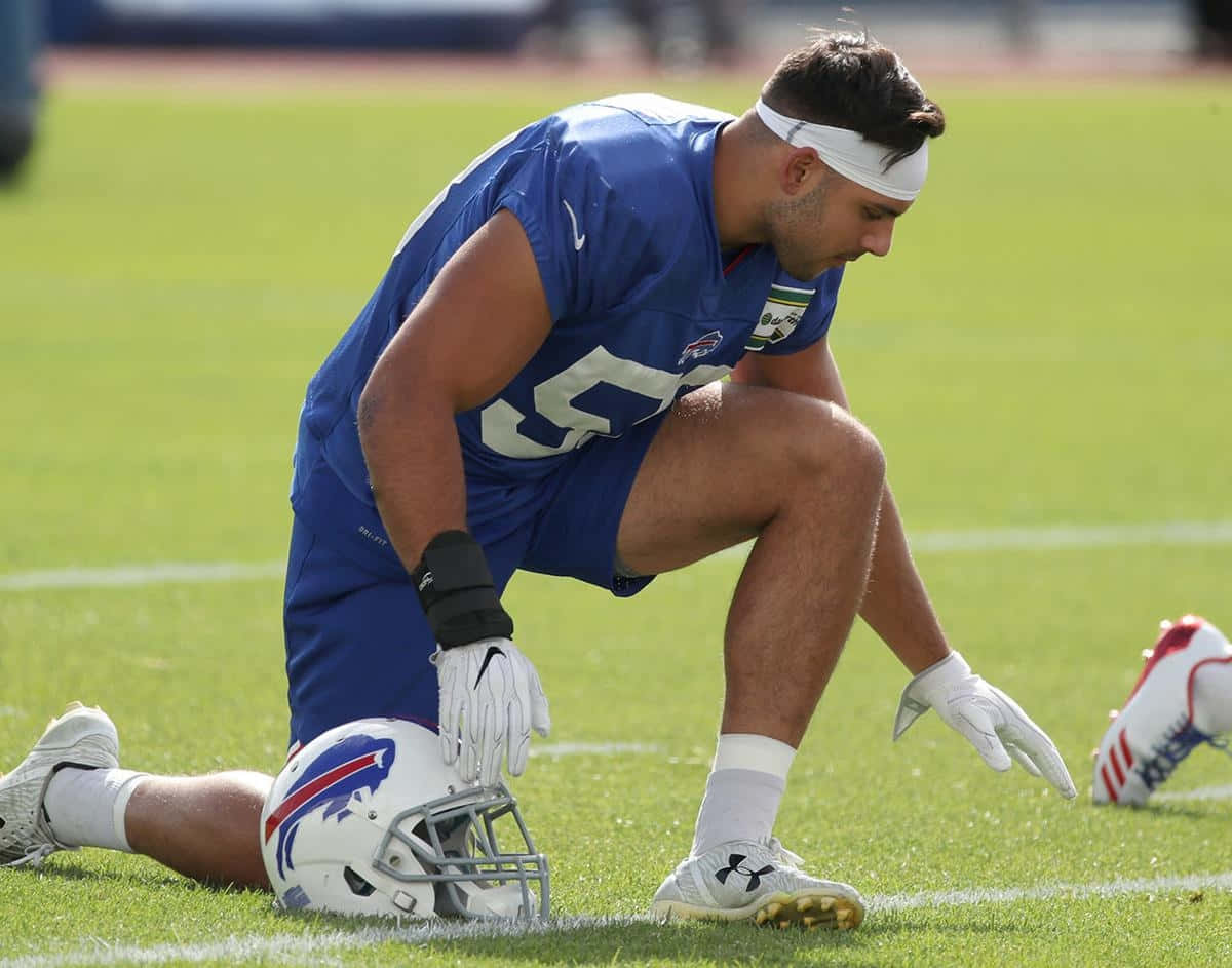 Football Player Kneeling During Practice Wallpaper