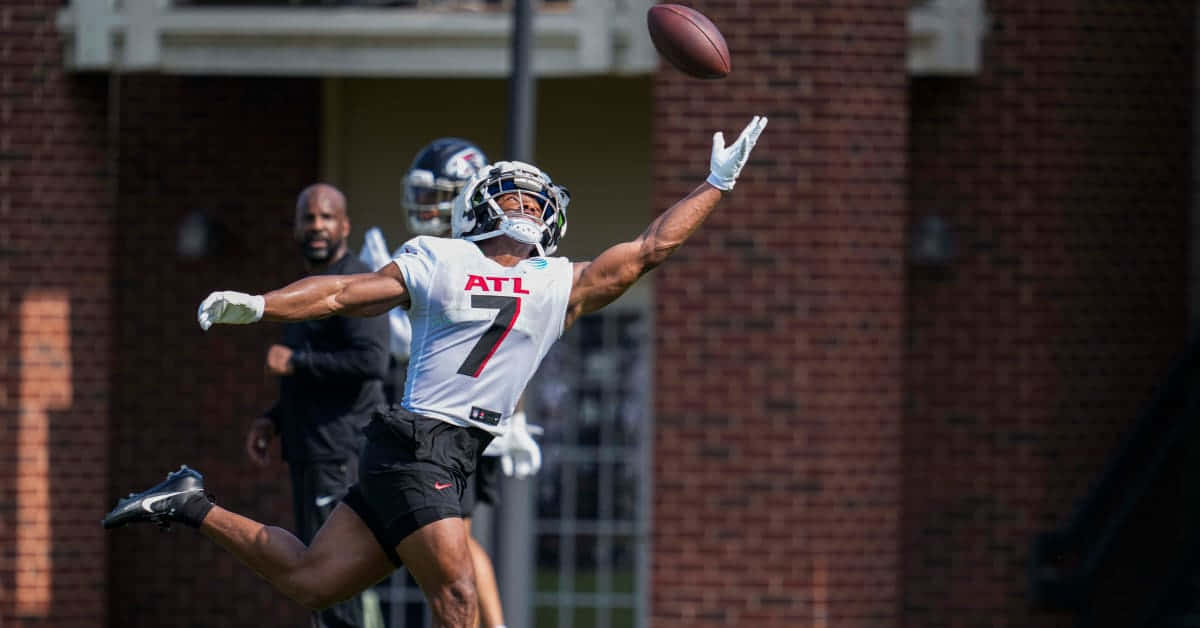 Football Player Leaping Catch Practice Wallpaper