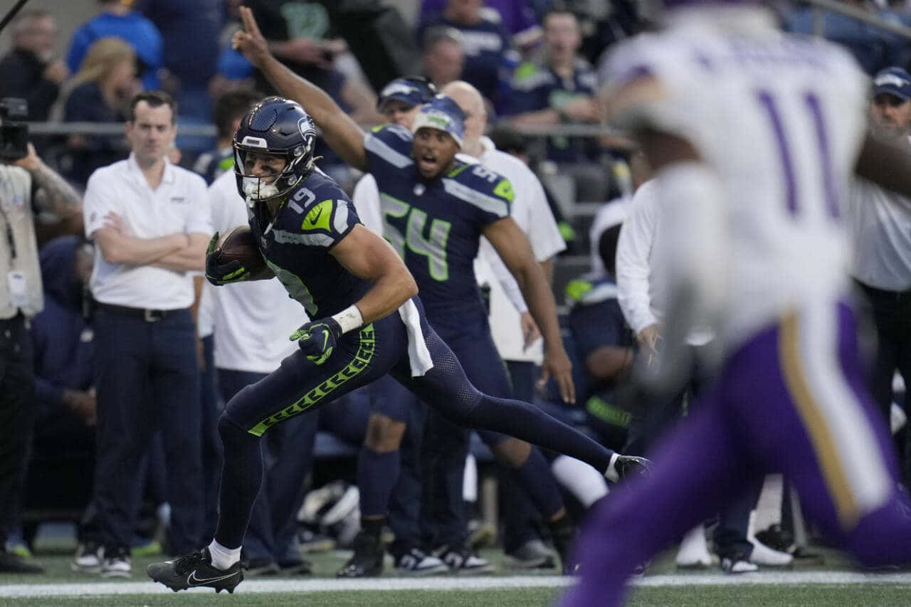 Football Player Running With Ball During Game Wallpaper