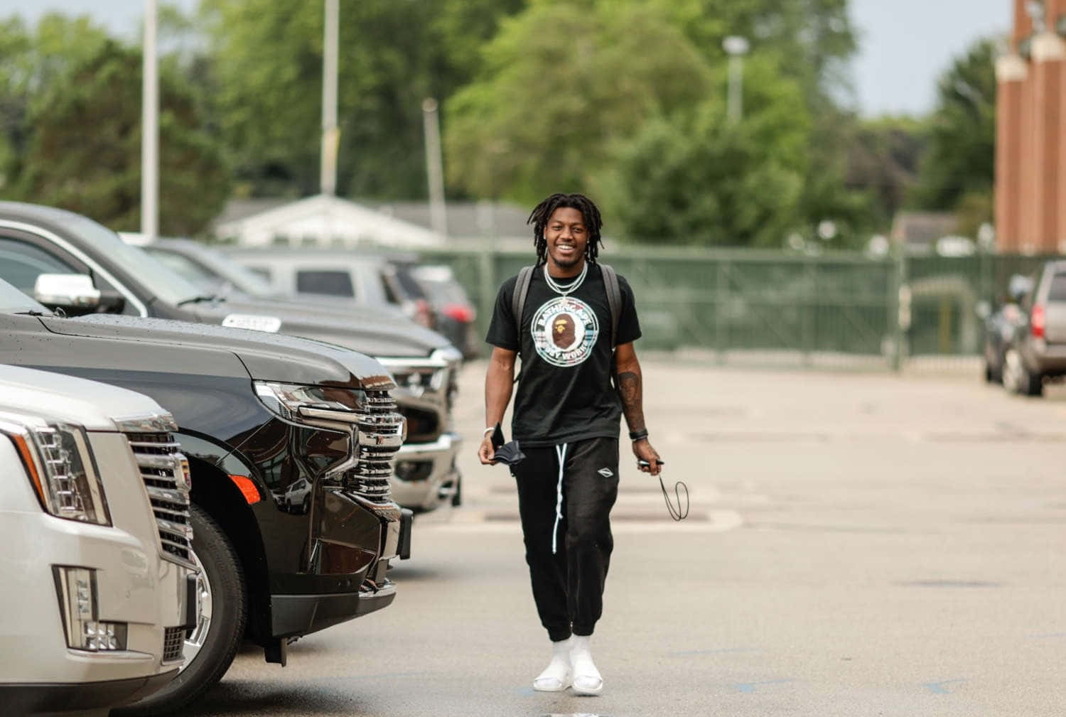 Football Player Walkingin Parking Lot Wallpaper