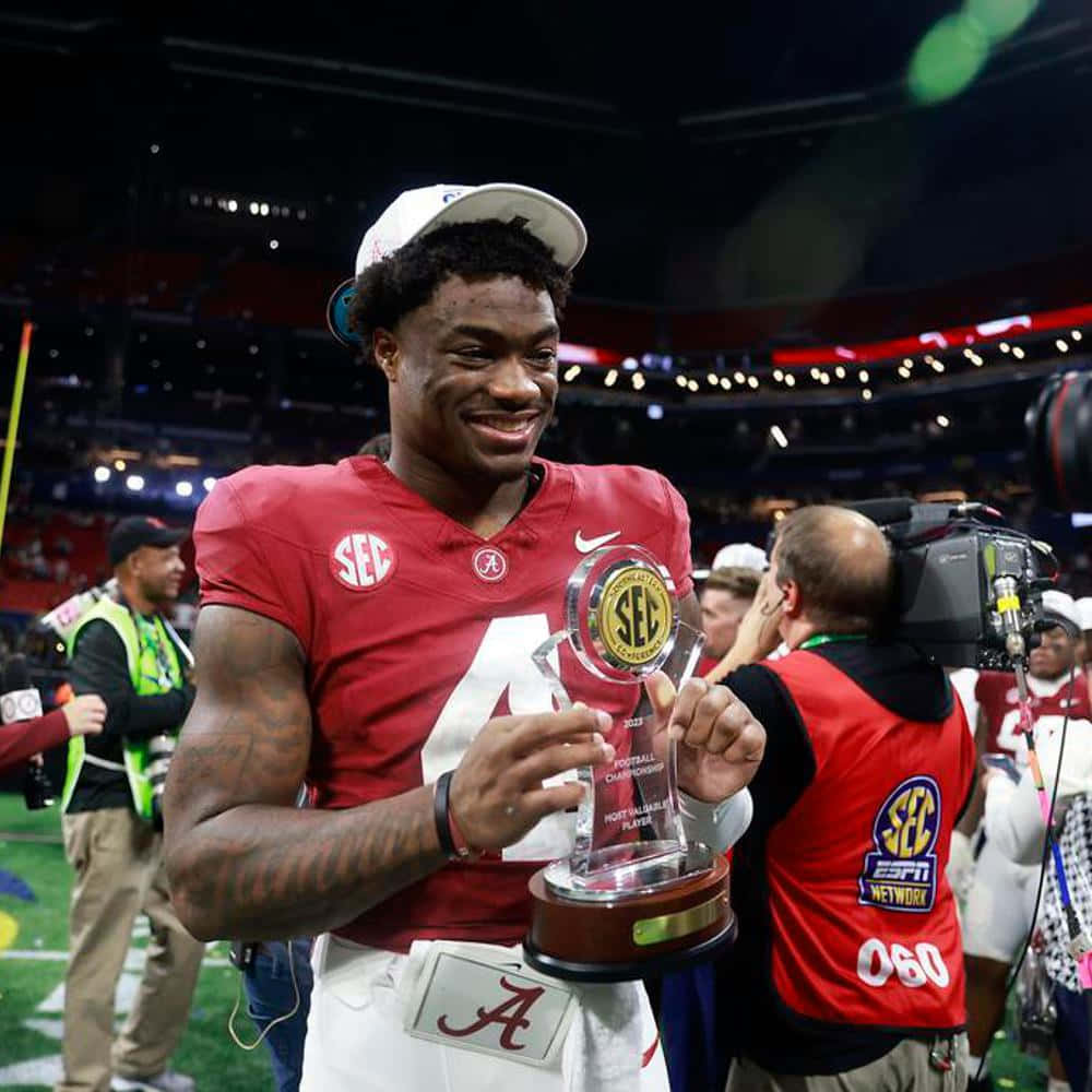 Football_ Player_with_ Trophy_at_ Stadium Wallpaper