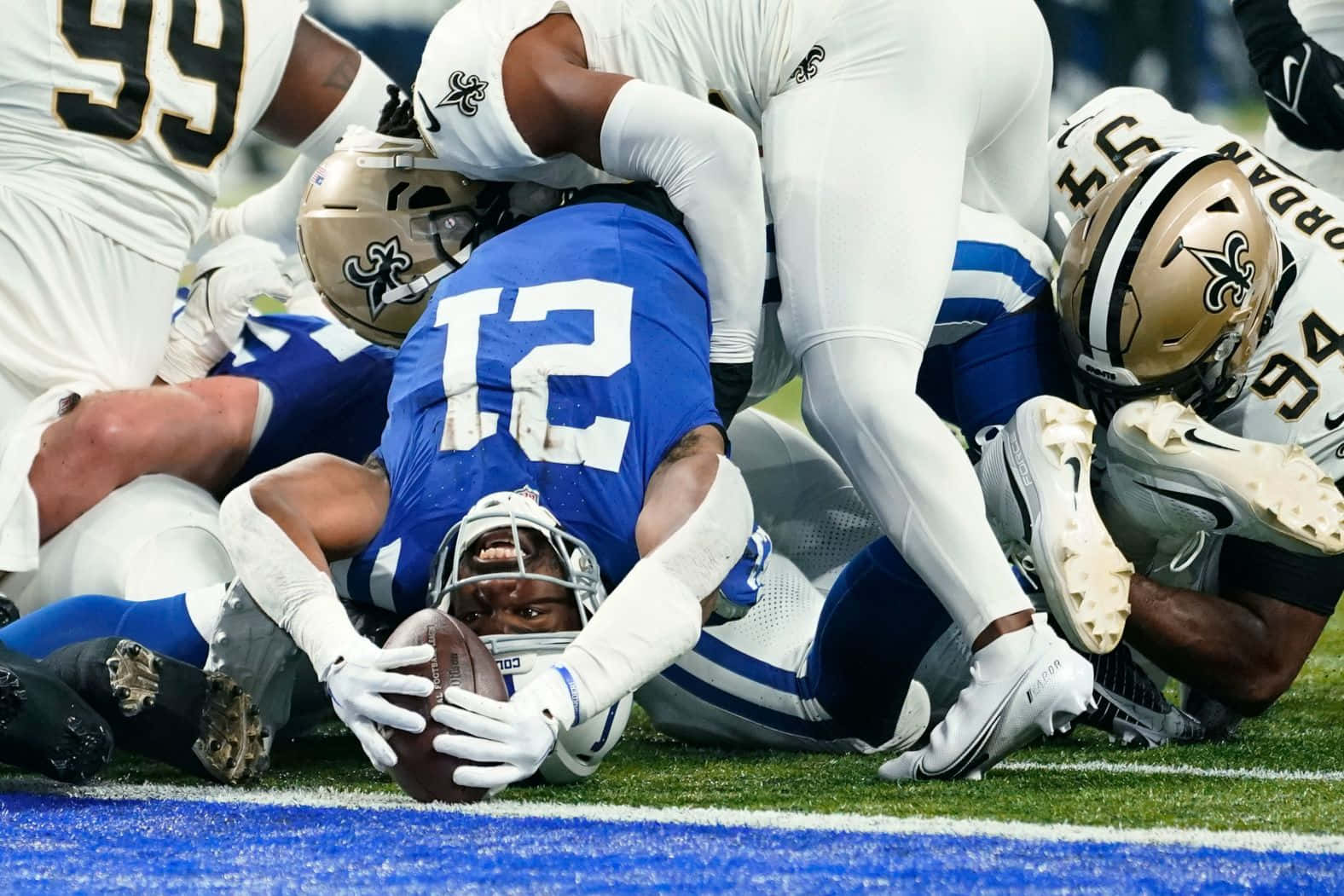 Football Player Zack Moss Tackled During Game Wallpaper