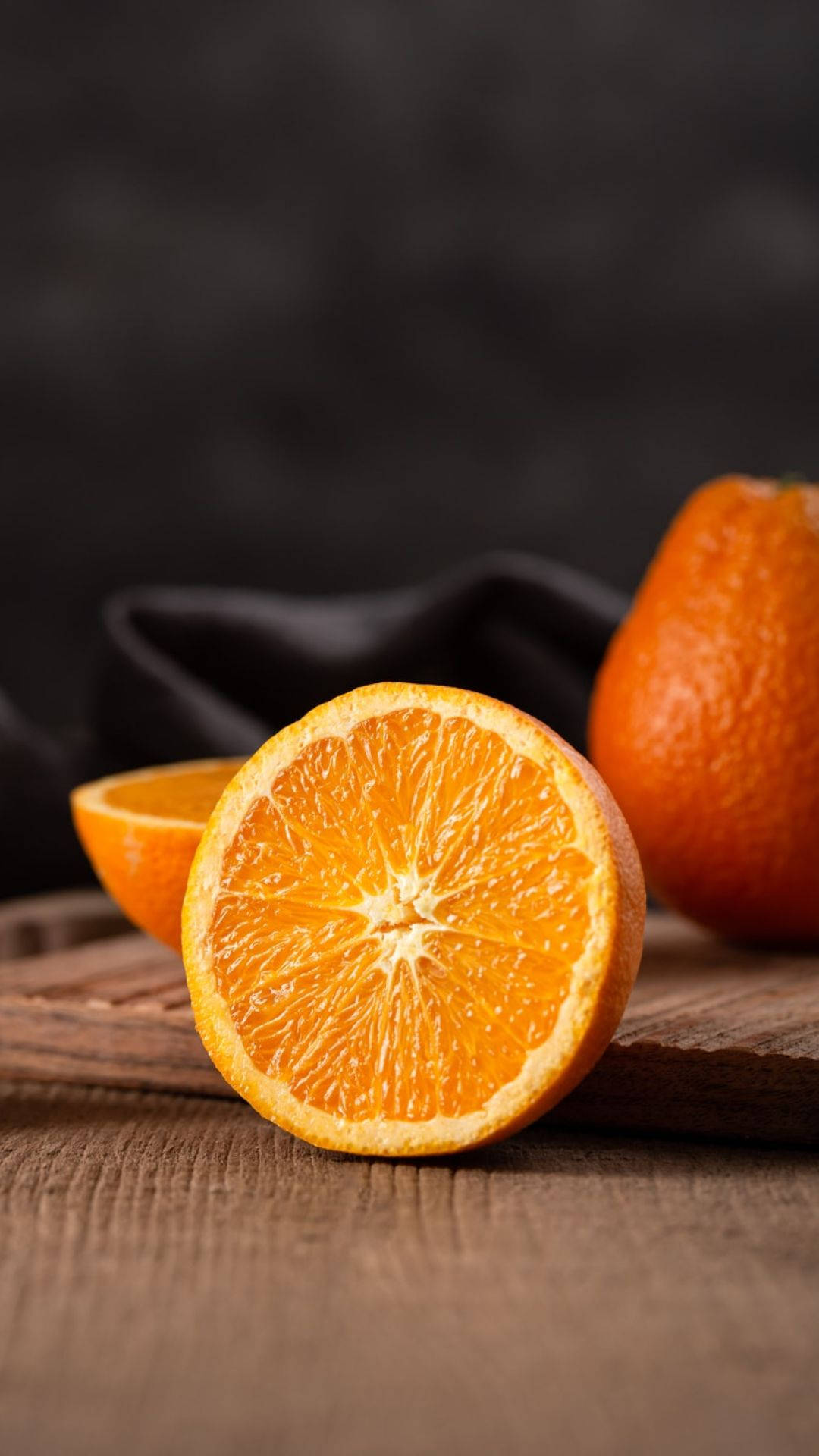 Freshly Sliced Orange On A Wooden Surface Wallpaper