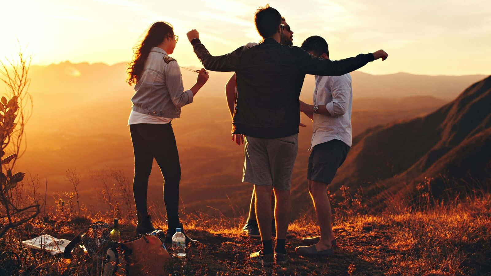 Friends Enjoying Sunset On Hilltop Wallpaper