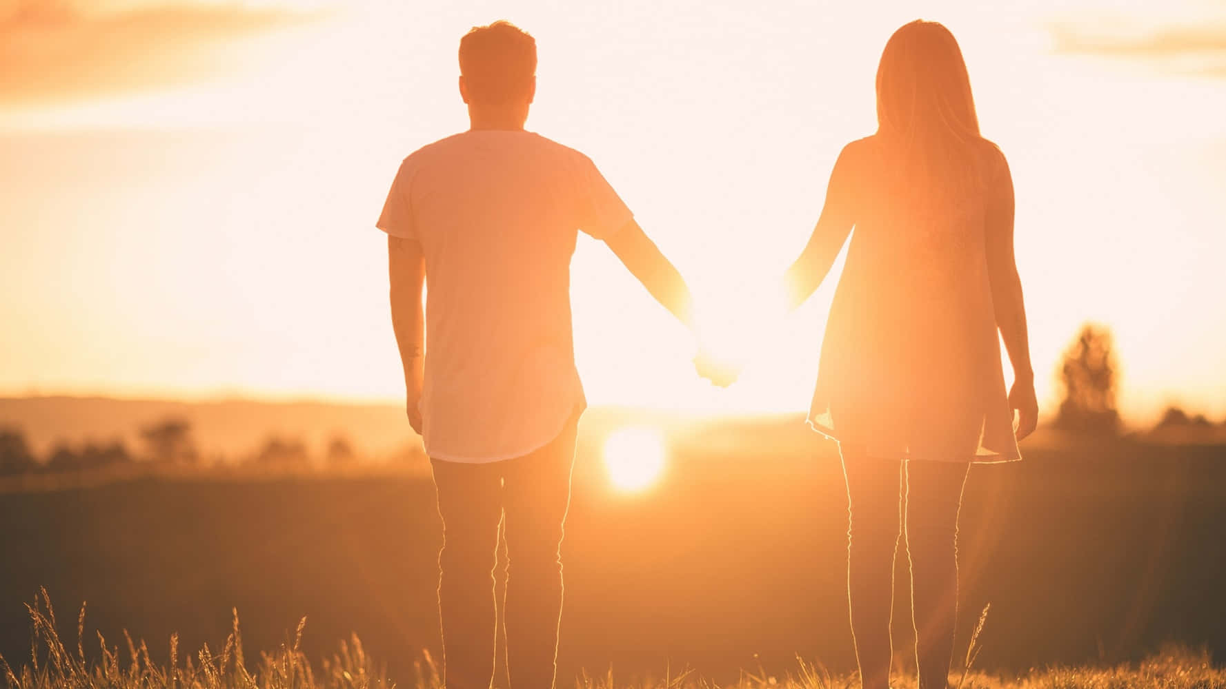 Girlfriend And Boyfriend Holding Hands During Sunset Wallpaper