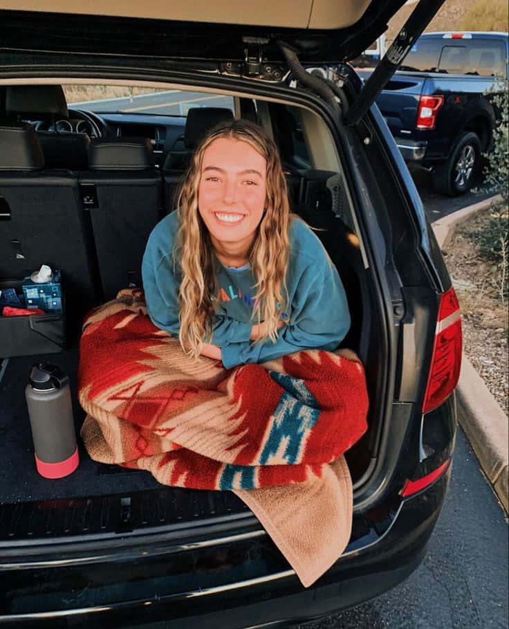 Granola Aesthetic Smiling Girl In Car Trunk Wallpaper