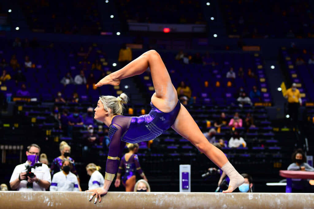 Gymnast Performing Balance Beam Routine Wallpaper