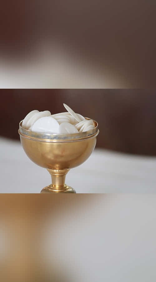 Hands Holding A Chalice During A Sacrament Ceremony Wallpaper