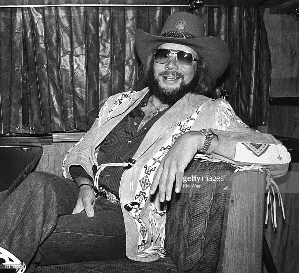 Hank Williams Jr. Strumming A Guitar On-stage Wallpaper