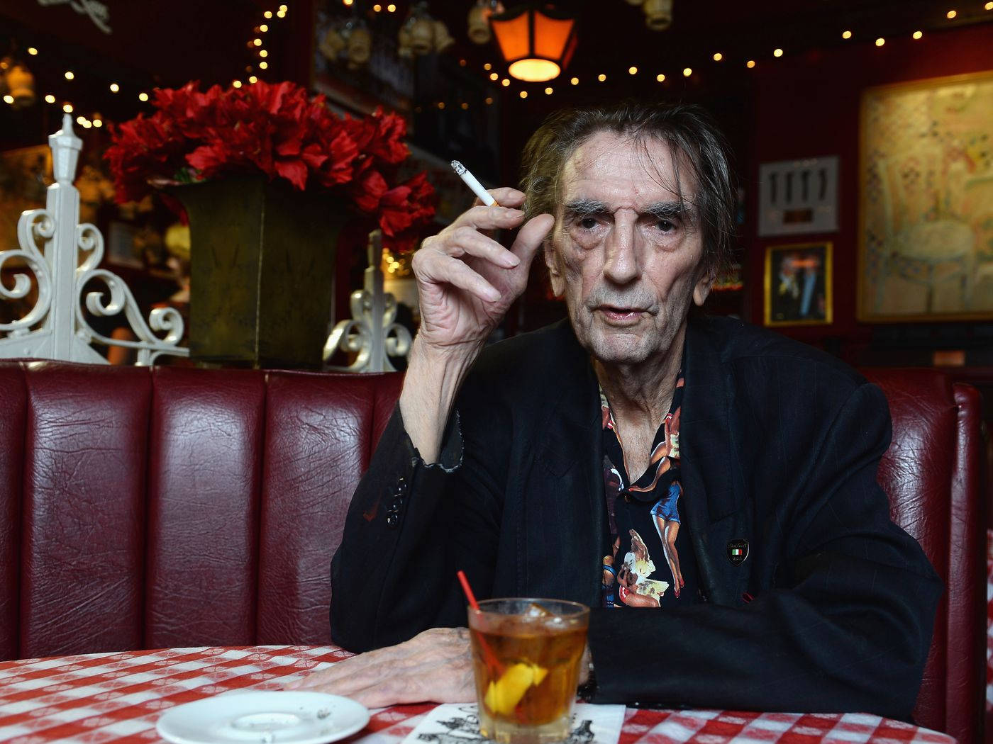 Harry Dean Stanton Smoking Cigarette On Table Wallpaper