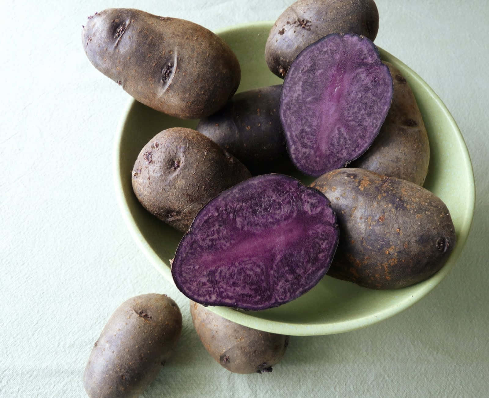 Having A Bite Into The Purple Goodness Of A Purple Potato Wallpaper