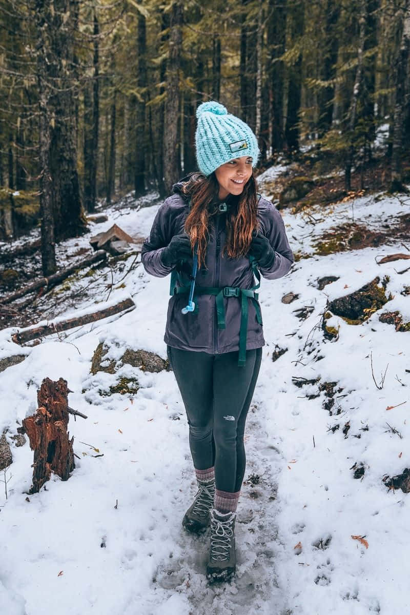 Hikers Enjoying A Beautiful Snowy Mountain View During A Winter Hike Wallpaper