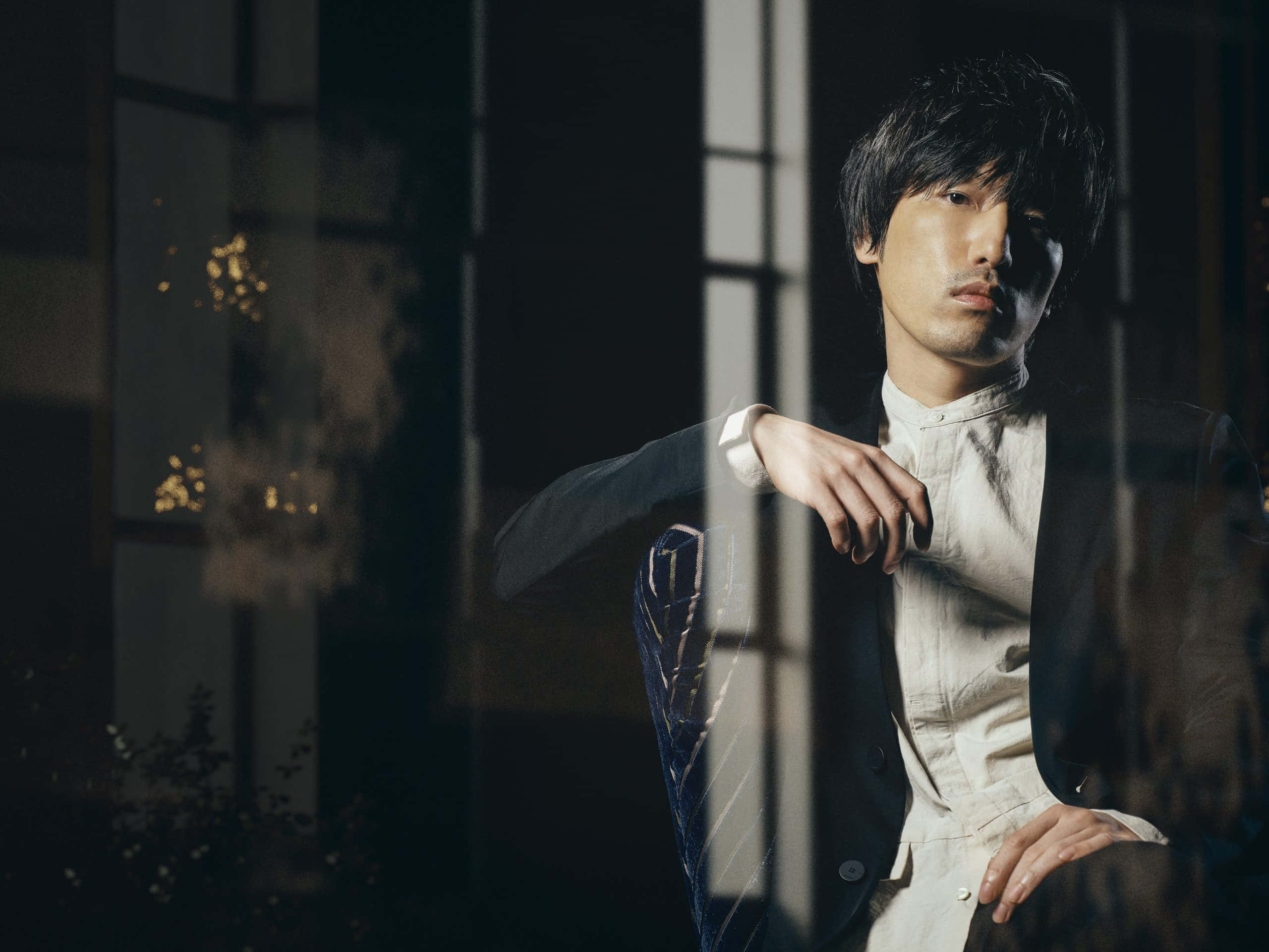 Hiroyuki Sawano Stands At The Top Of Orchestra Podium Wallpaper