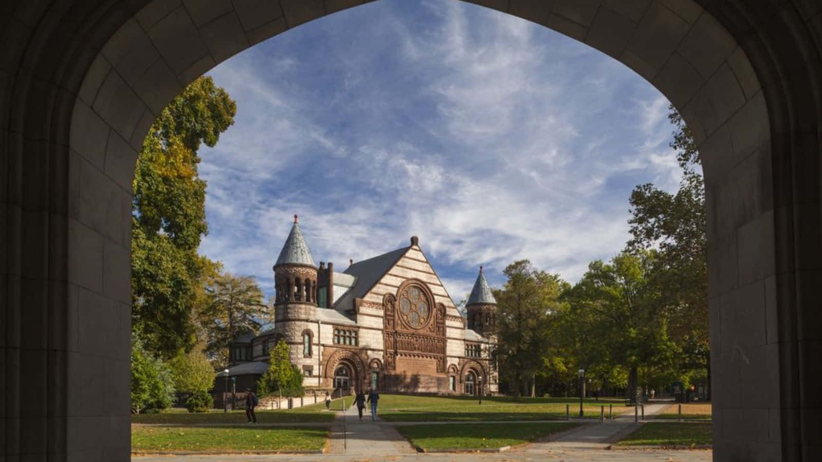 Historic College Building Viewed Through Archway Wallpaper