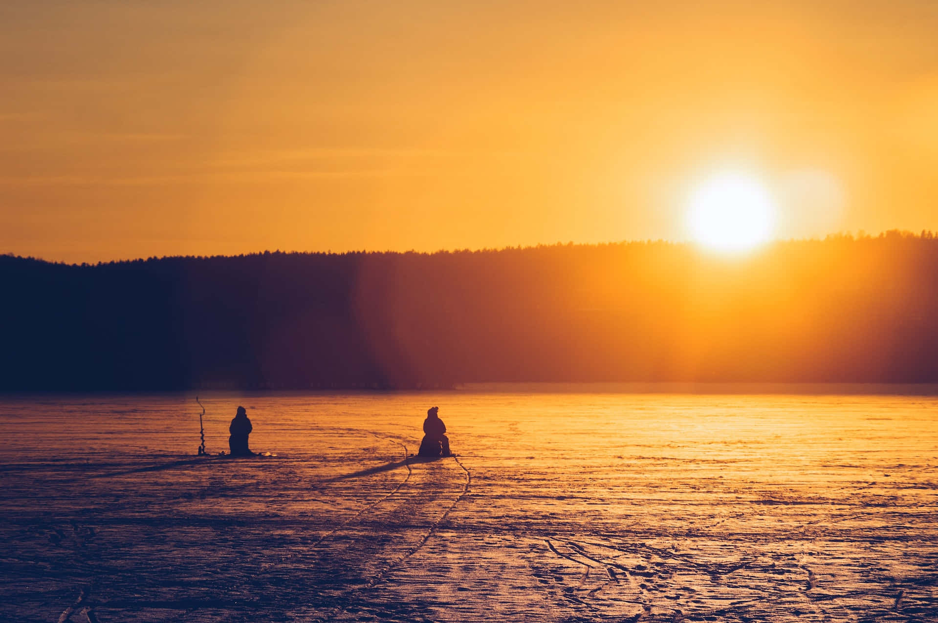 Ice Fishing Enthusiasts On A Frozen Lake Wallpaper