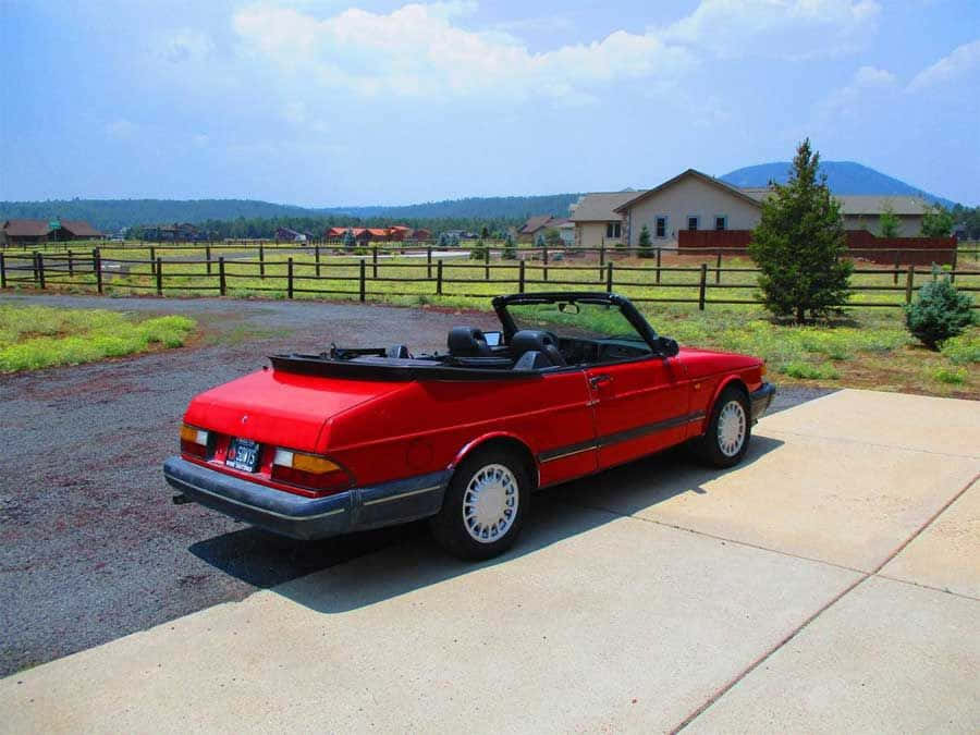 Iconic Vintage Saab 900 Turbo In A Serene Countryside Setting. Wallpaper