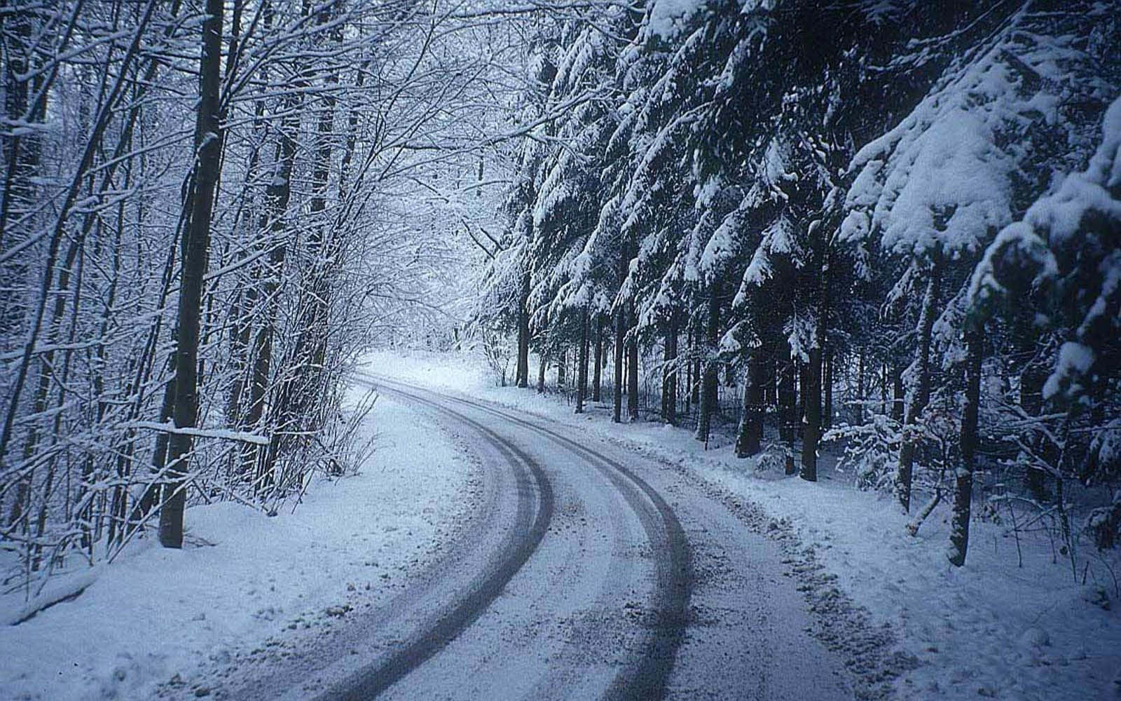 Icy Road Blending Into Snowy Landscape Wallpaper