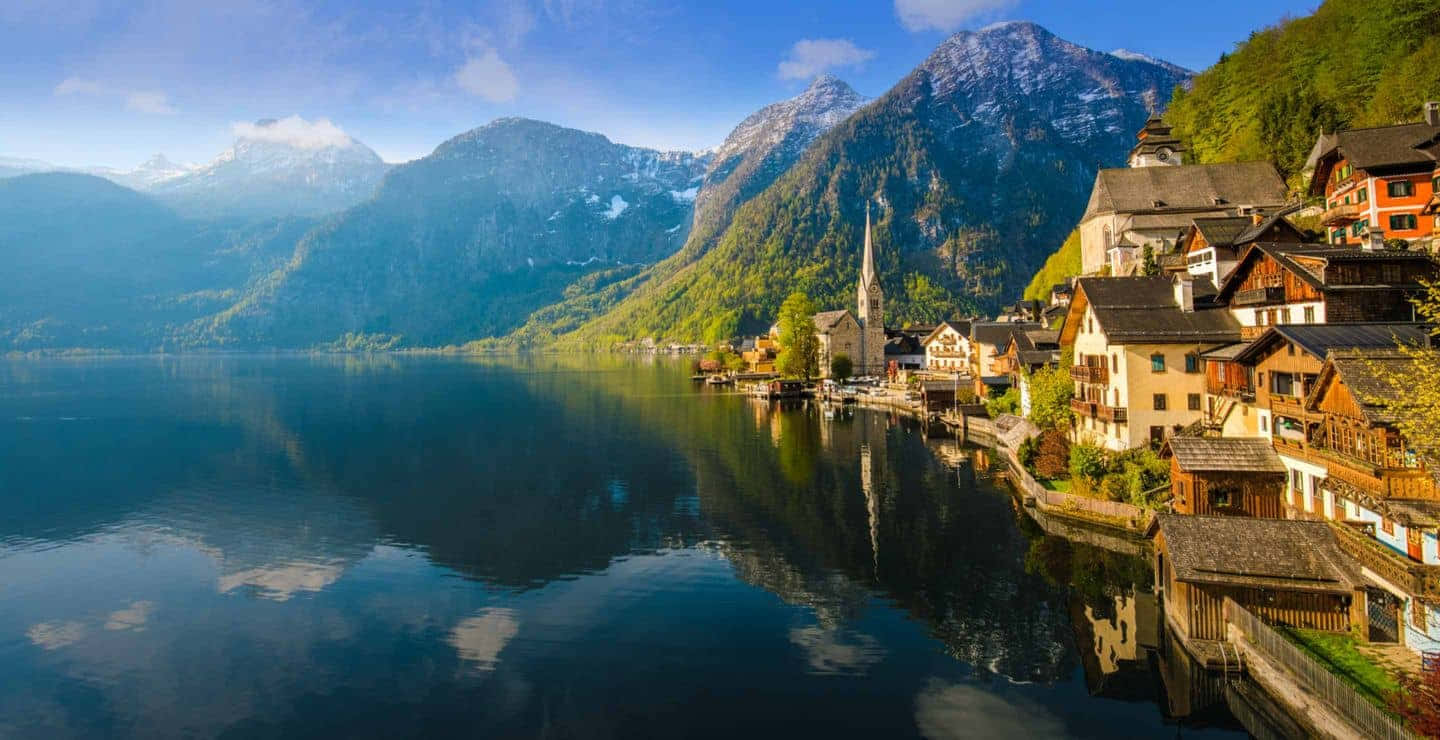 Idyllic Lakeside Village Mountain Reflection Wallpaper