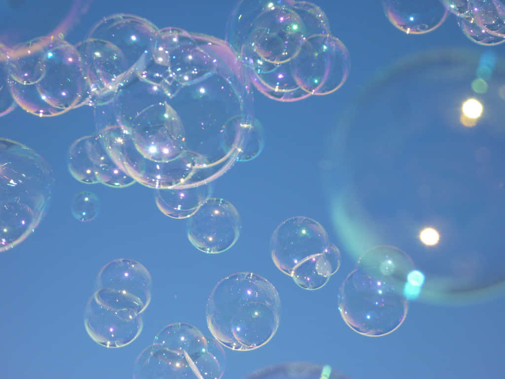 Iridescent Soap Bubbles Against Sky Wallpaper