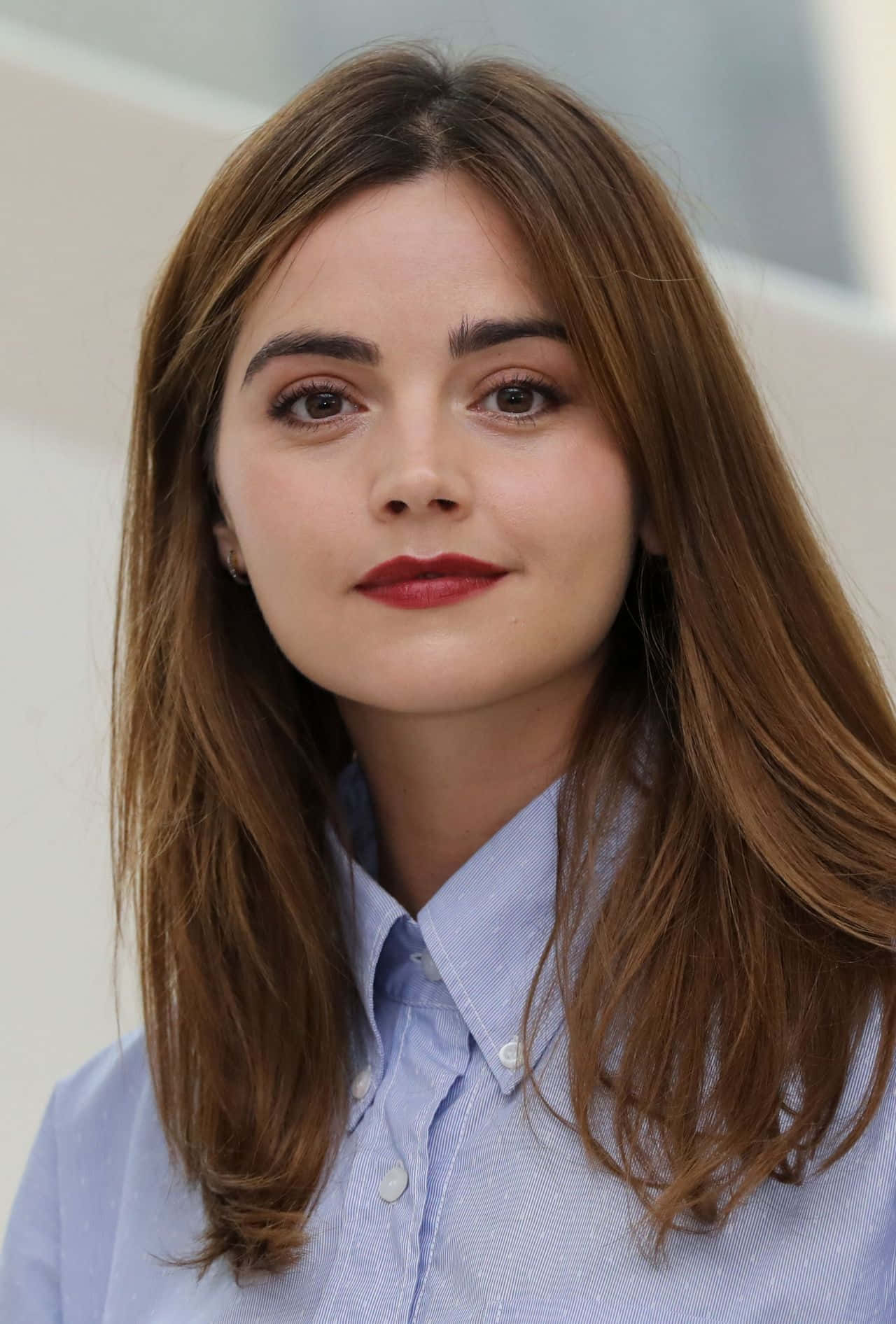 Jenna Coleman Posing Against A Colorful Backdrop Wallpaper