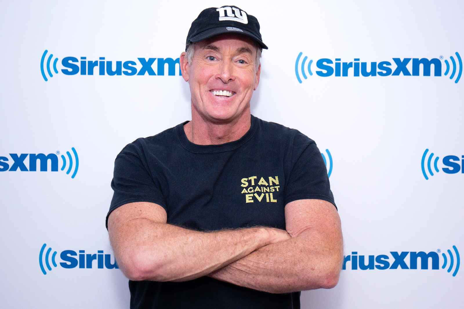 John C. Mcginley Smiling In A Relaxed Pose Wallpaper