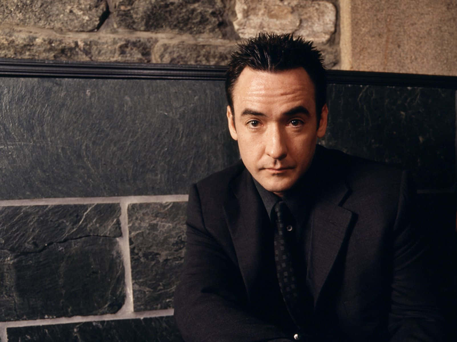 John Cusack Posing With A Black Leather Jacket Wallpaper