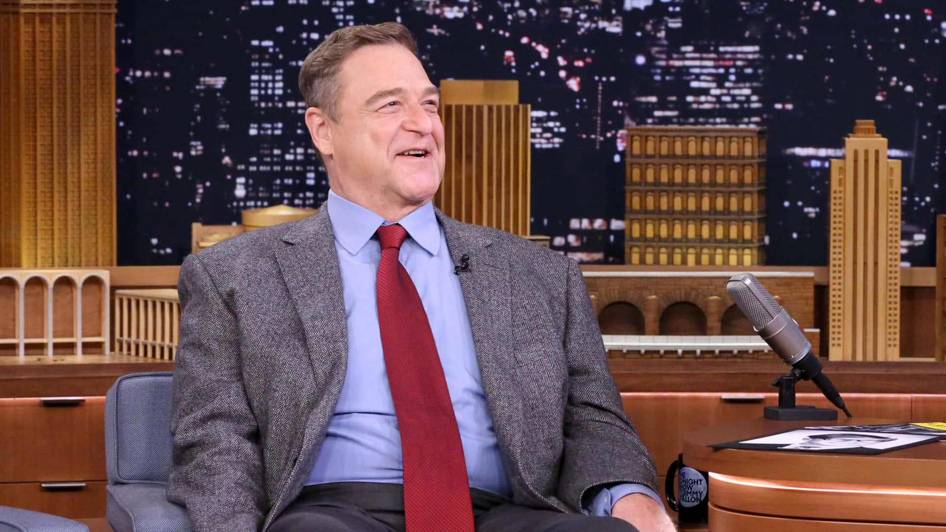 John Goodman Smiling At A Press Event Wallpaper