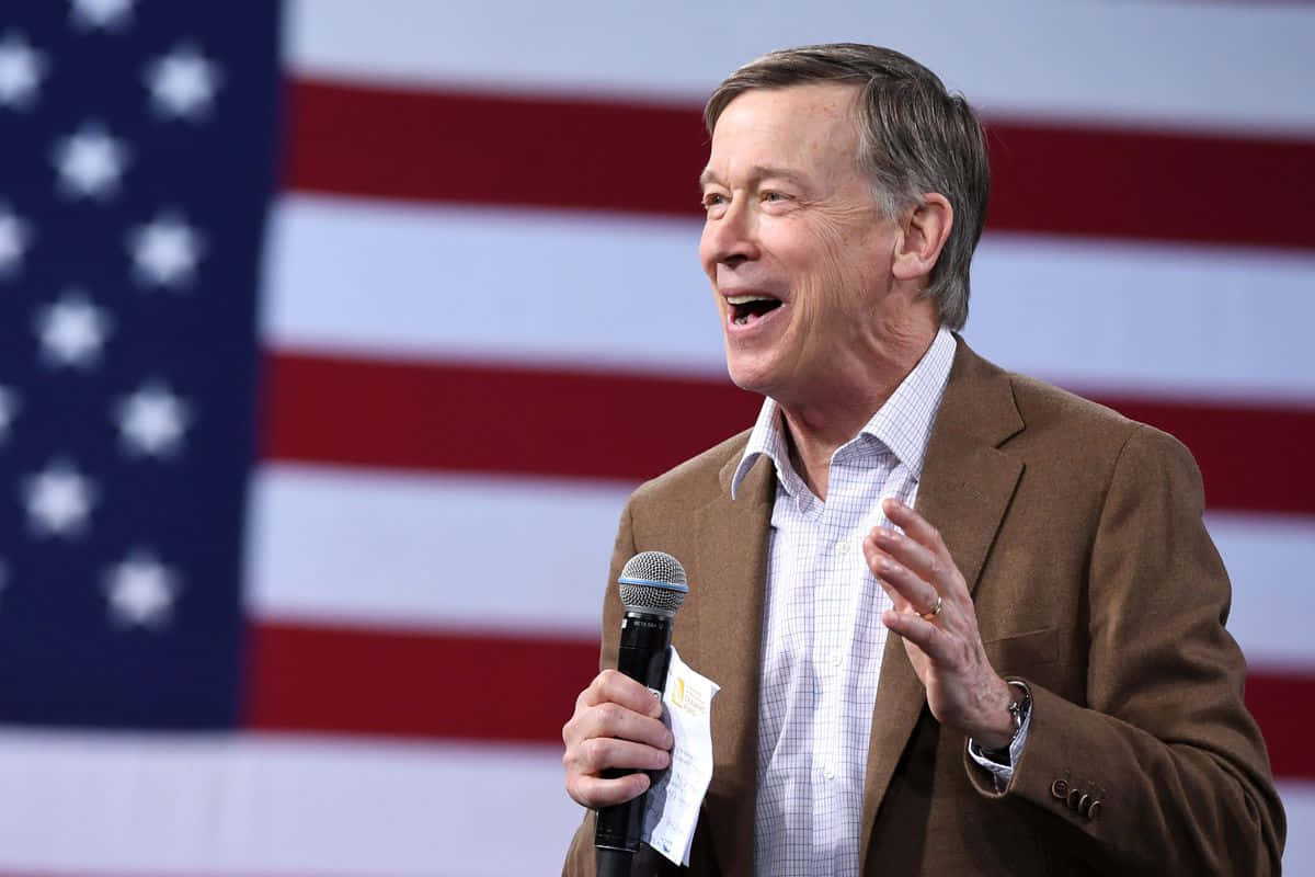 John Hickenlooper In Front Of The American Flag Wallpaper