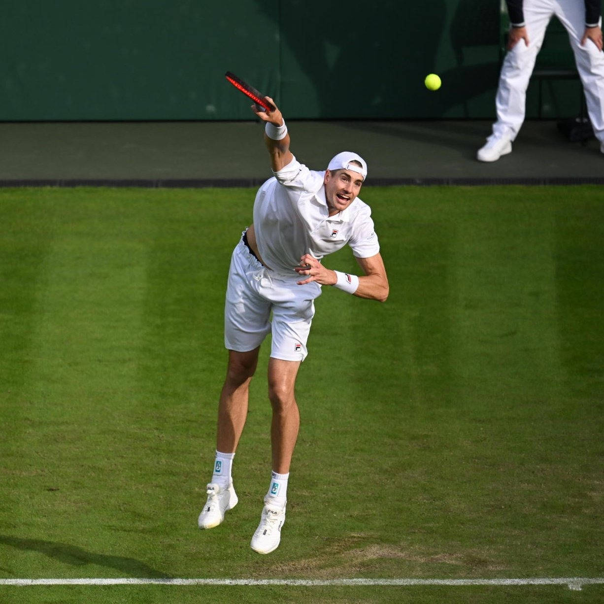 John Isner Exhibiting His Tennis Skills In A Match Wallpaper