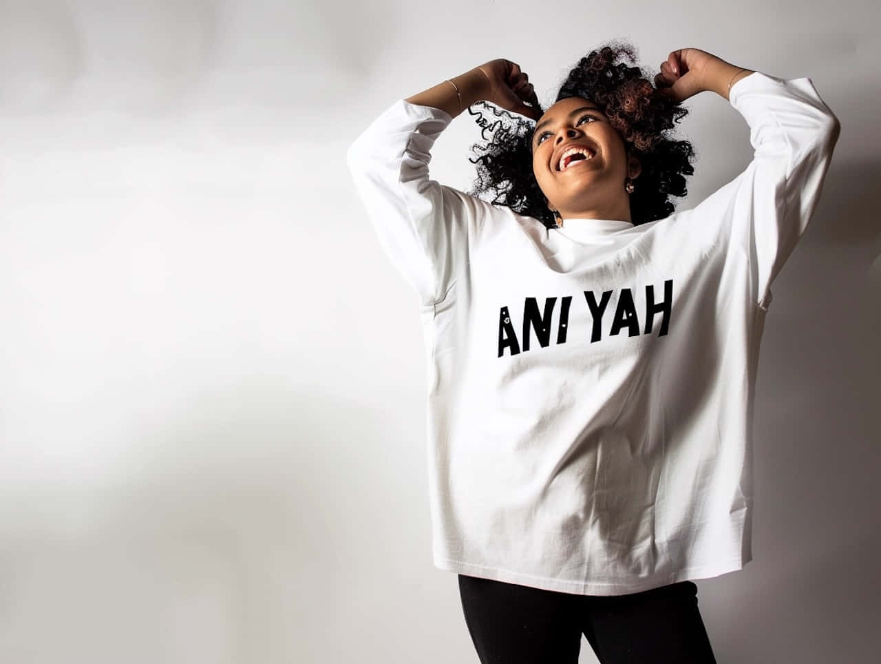 Joyful Woman Wearing Aniyah Sweatshirt Wallpaper