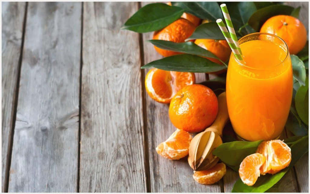 Juice With Orange Fruits And Leaves Wallpaper