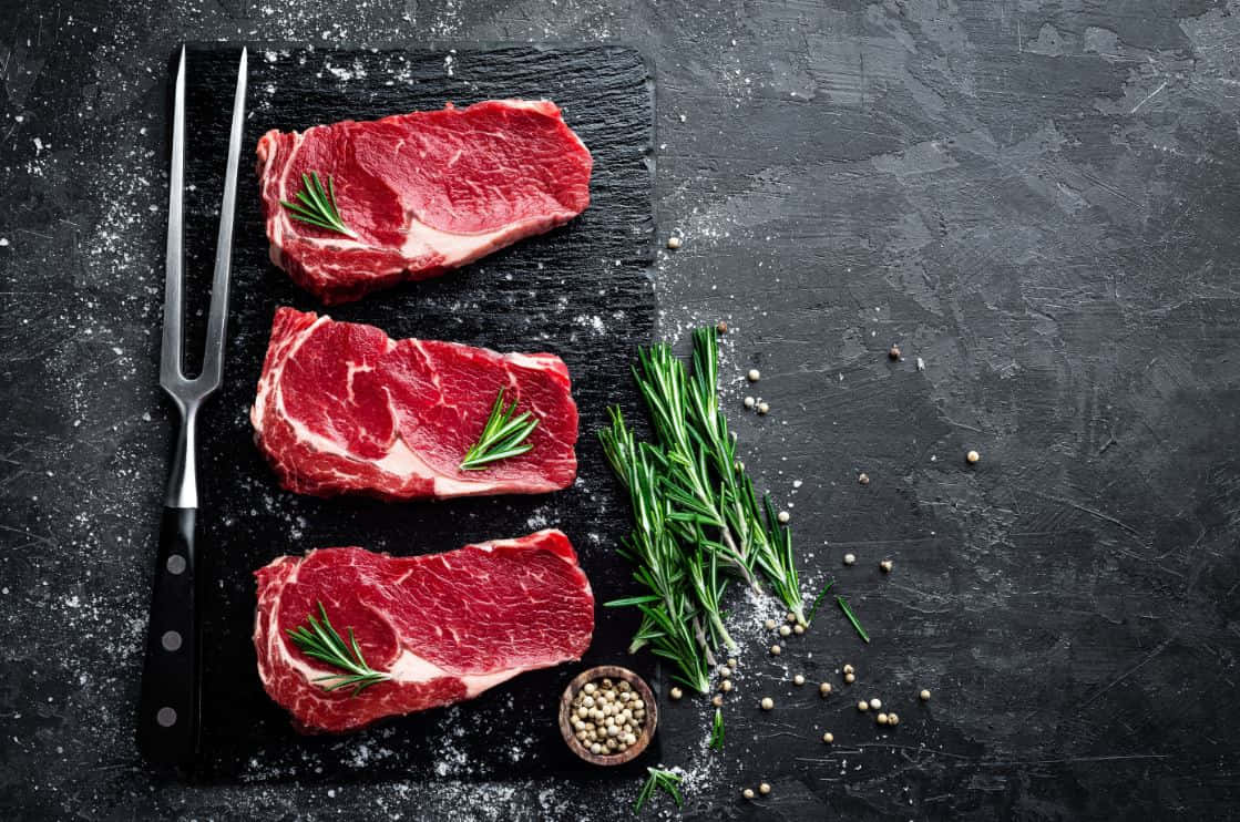 Juicy And Delicious Red Meat On A Wooden Table Wallpaper