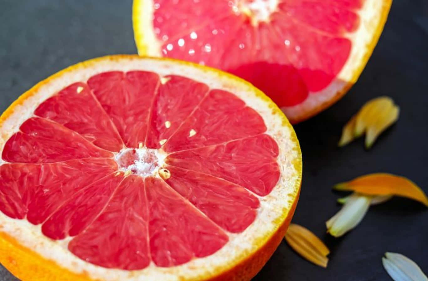 Juicy Pink Grapefruit Slices On A White Surface Wallpaper