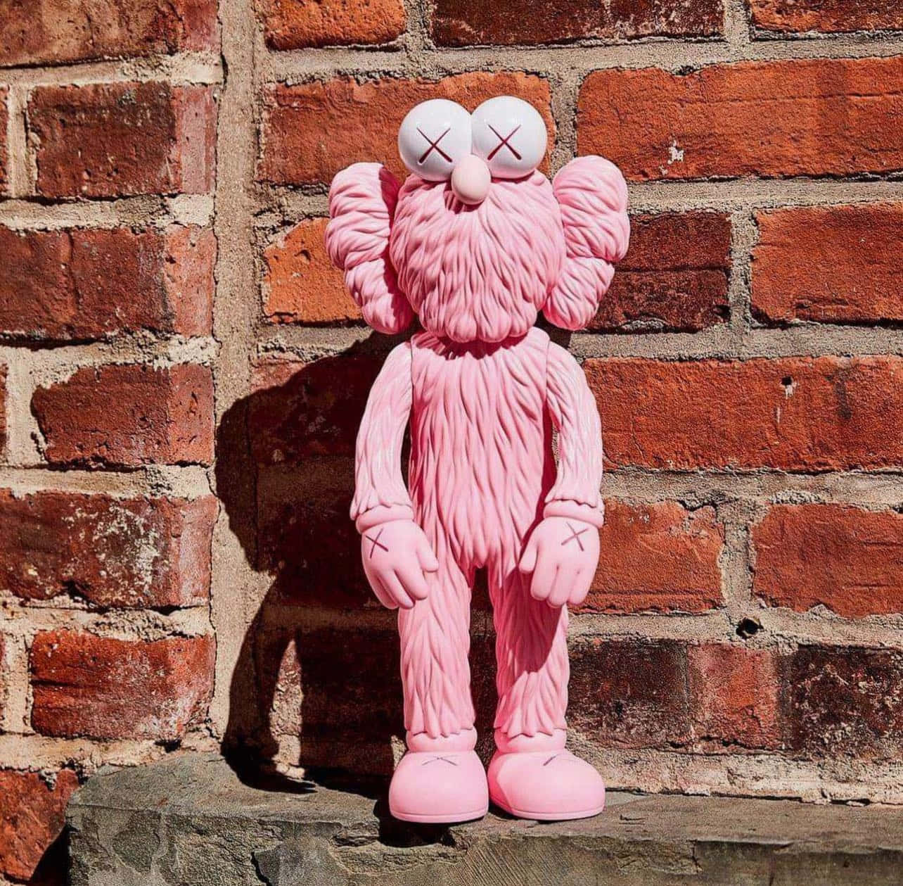 Kaws B F F Pink Figure Brick Background Wallpaper