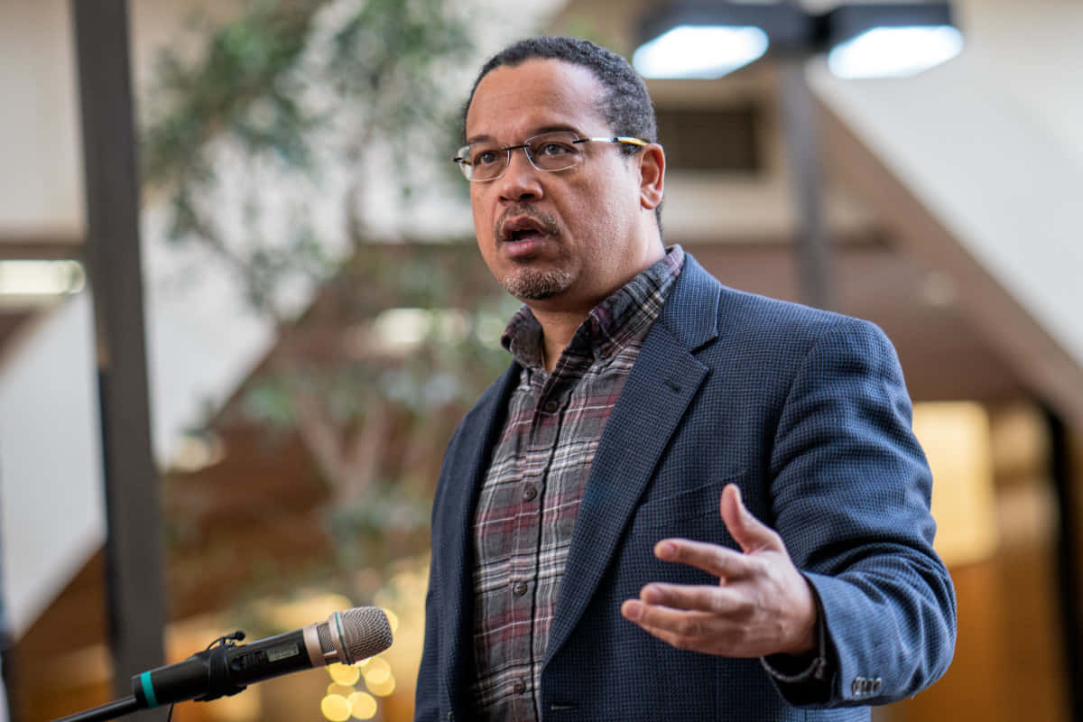 Keith Ellison Looking Professional In Plaid Shirt And Blazer Wallpaper