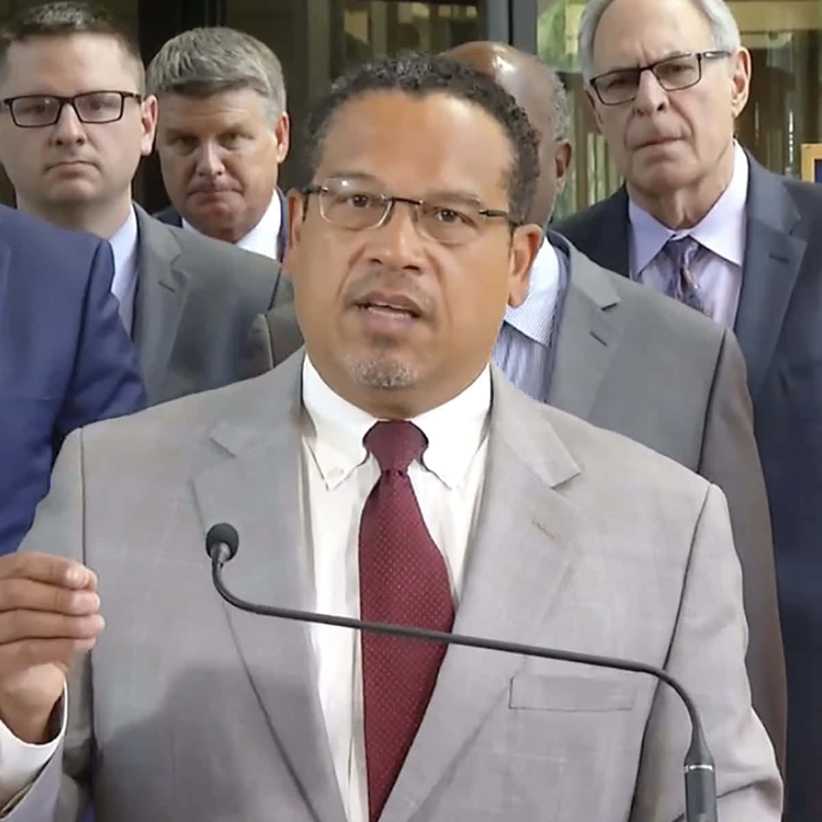 Keith Ellison With Men Behind Him Wallpaper