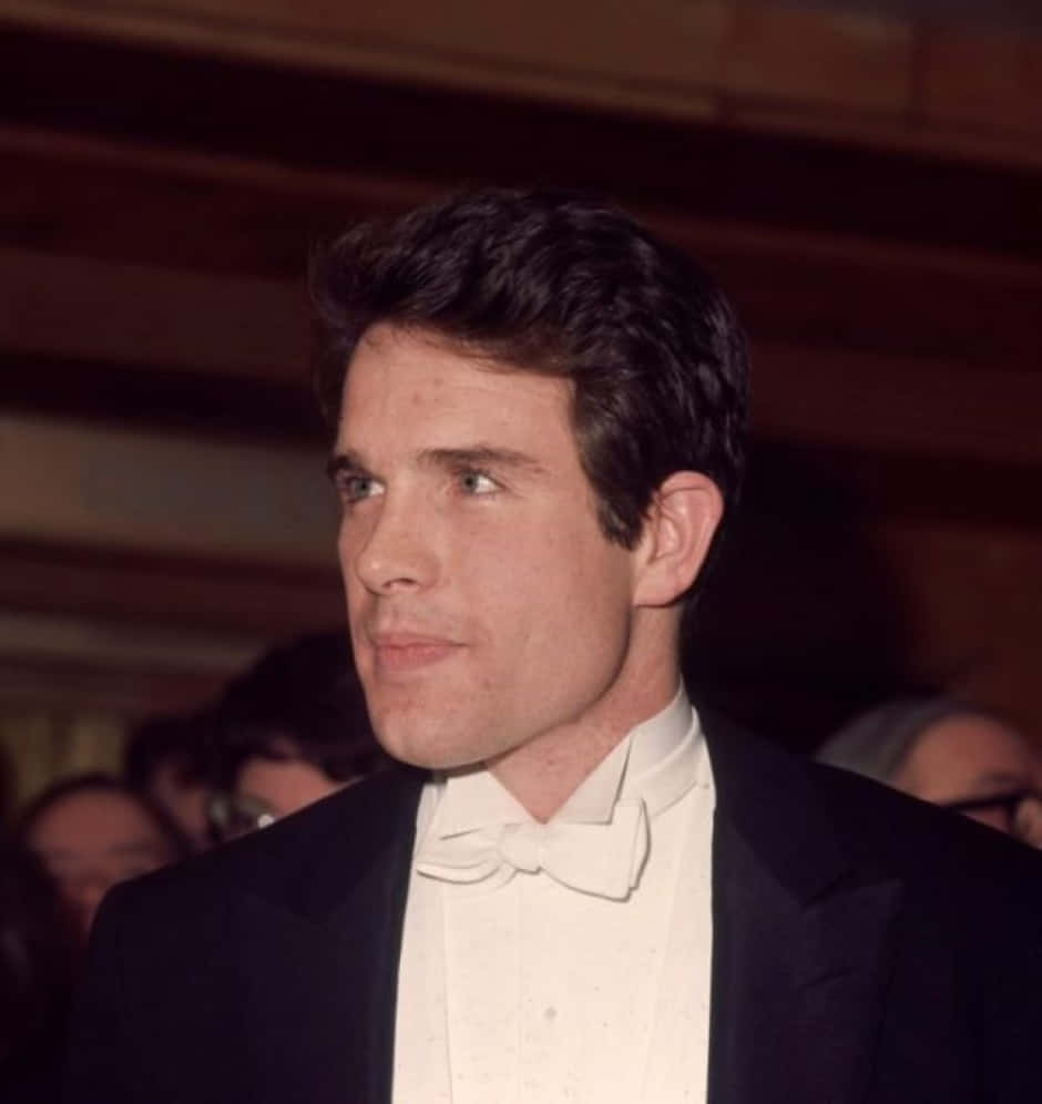 Legendary Actor Warren Beatty Smiling In A Classic Black Suit Wallpaper