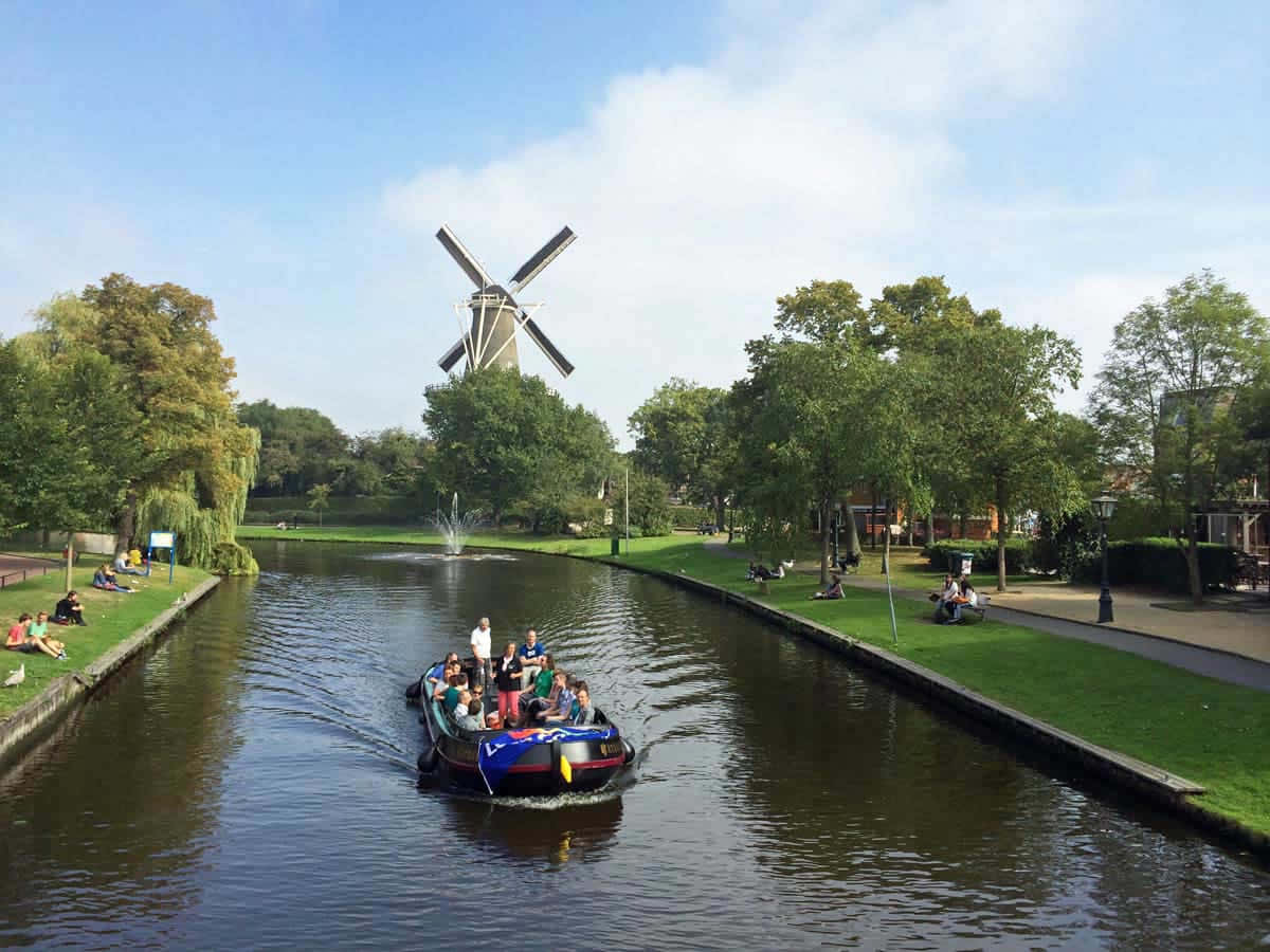 Leiden Canal Tour With Windmill View Wallpaper