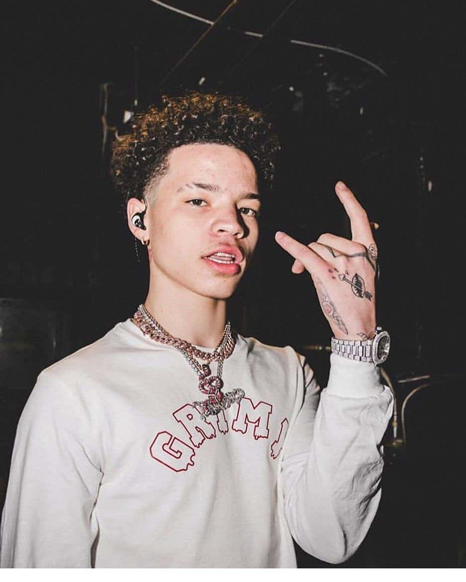 Lil Mosey Dressed In A Bright Yellow Jacket And Pants, Standing Confidently In Front Of A Grey Background. Wallpaper