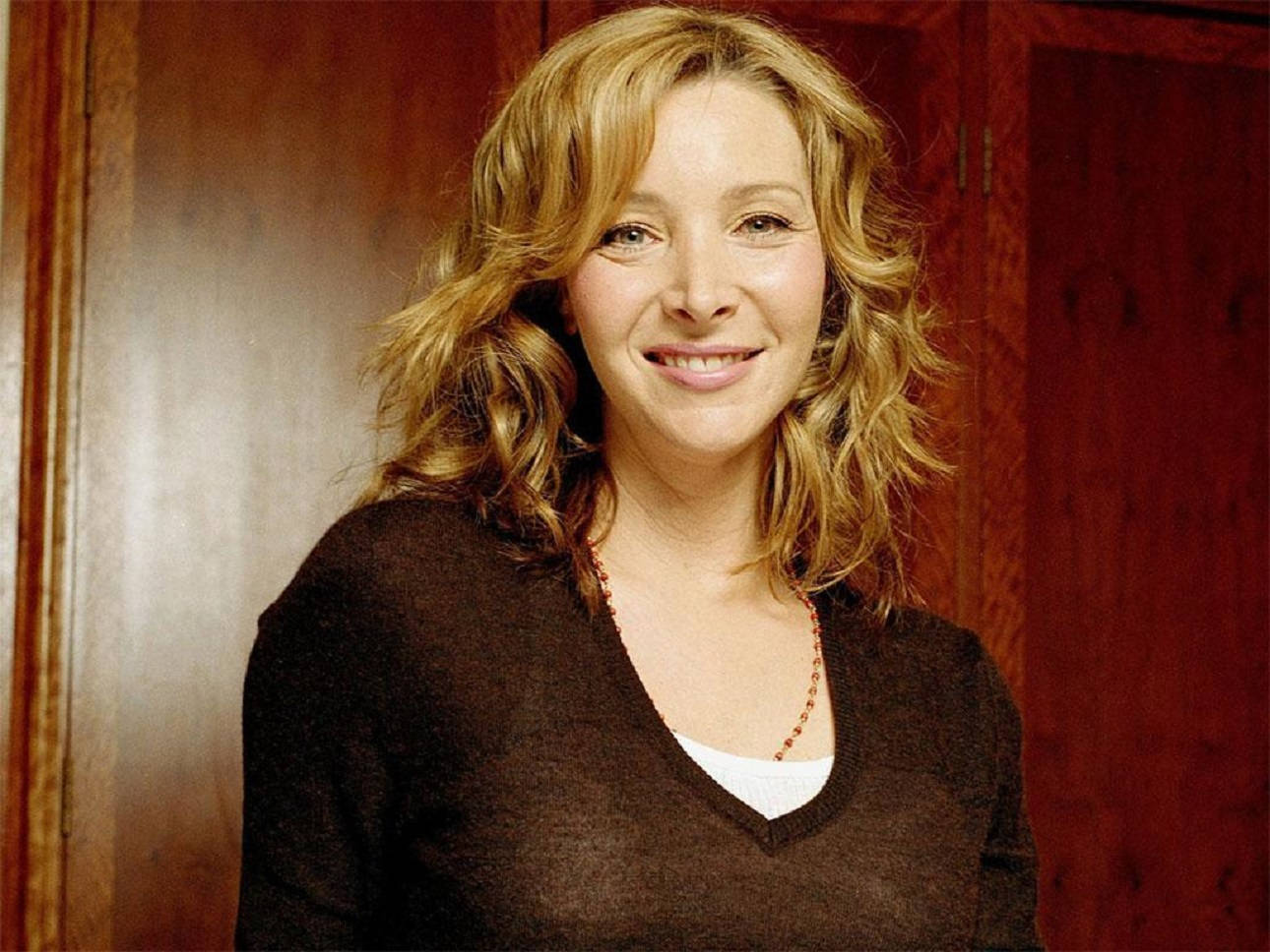 Lisa Kudrow Against Wood Wall Wallpaper