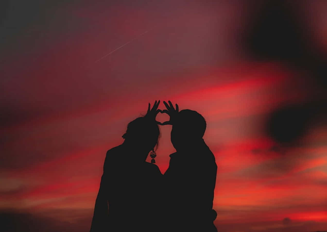 Loving Heart Silhouette At Sunset Wallpaper