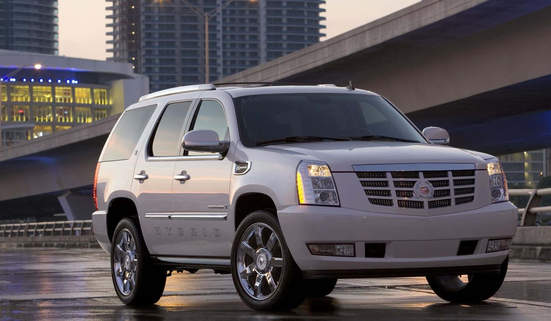 Luxurious Cadillac Escalade Cruising On The Road Wallpaper