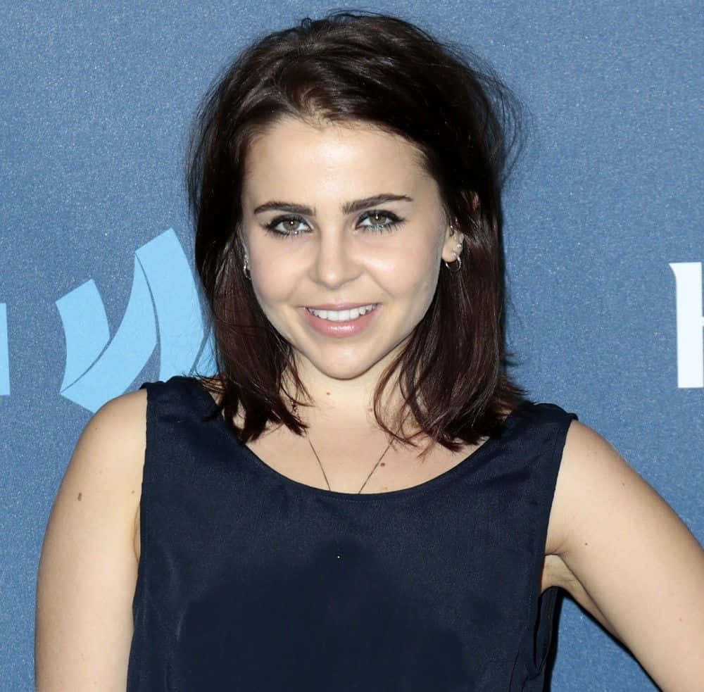 Mae Whitman Striking A Pose In A Chic Outfit Wallpaper