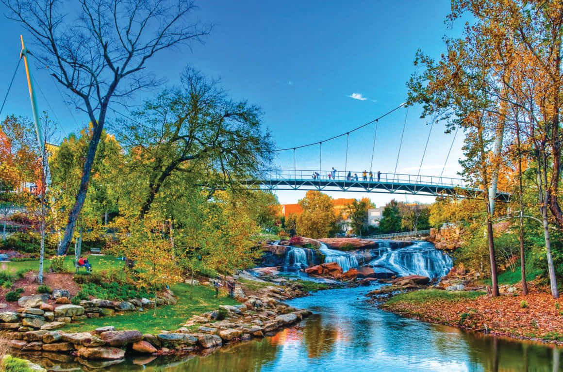 Majestic Fall Bridge Over Serene River Wallpaper