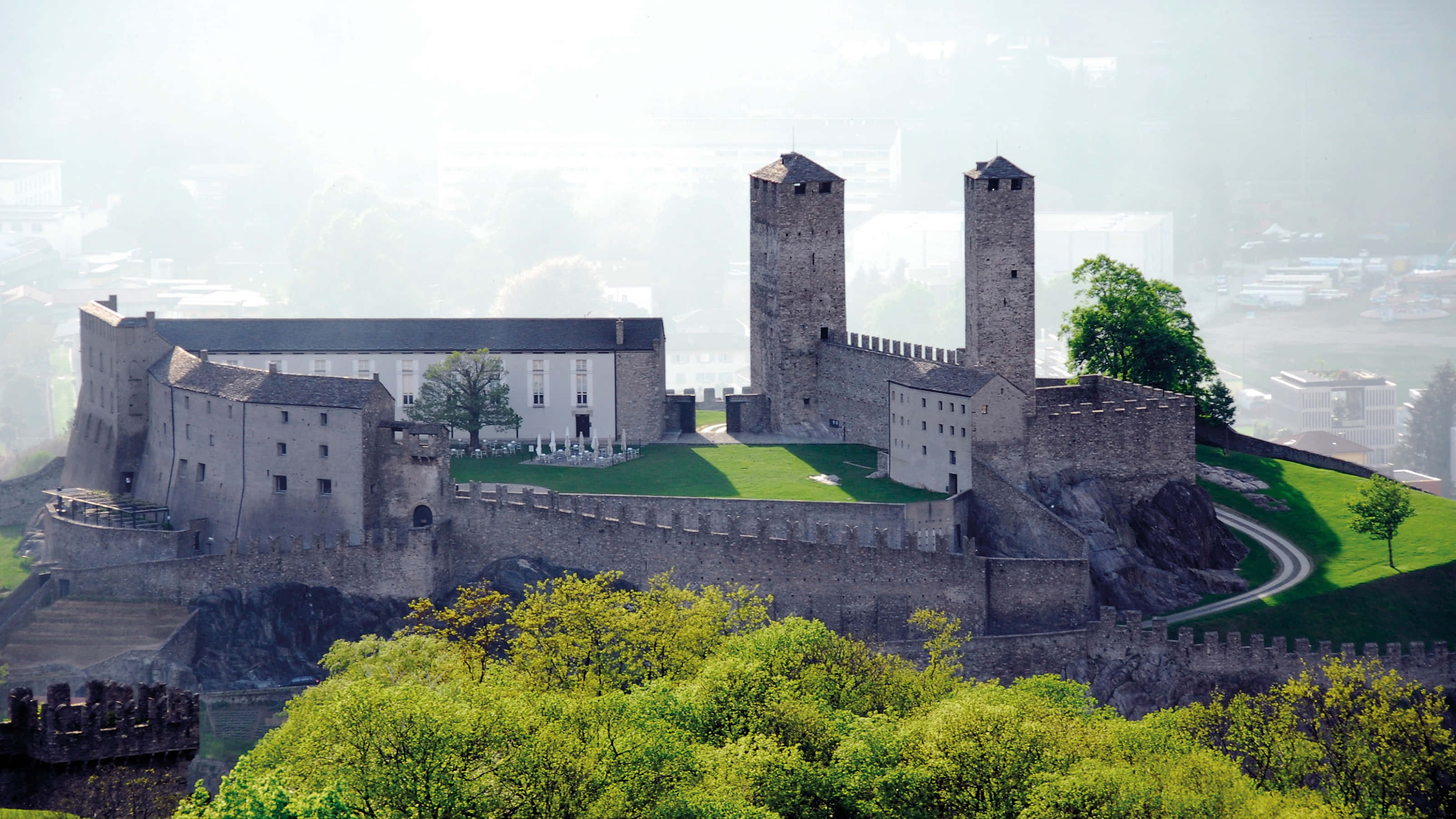 Majestic Three Castles Of Bellinzona Against A Blue Sky In Switzerland Wallpaper