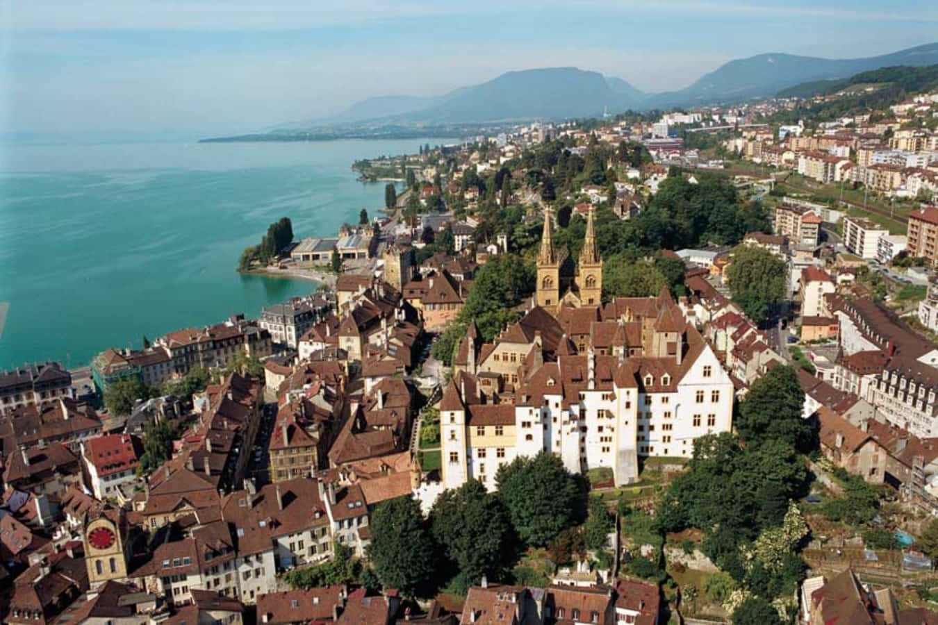 Majestic View Of Neuchâtel Lake Surrounded By Verdant Forests Wallpaper