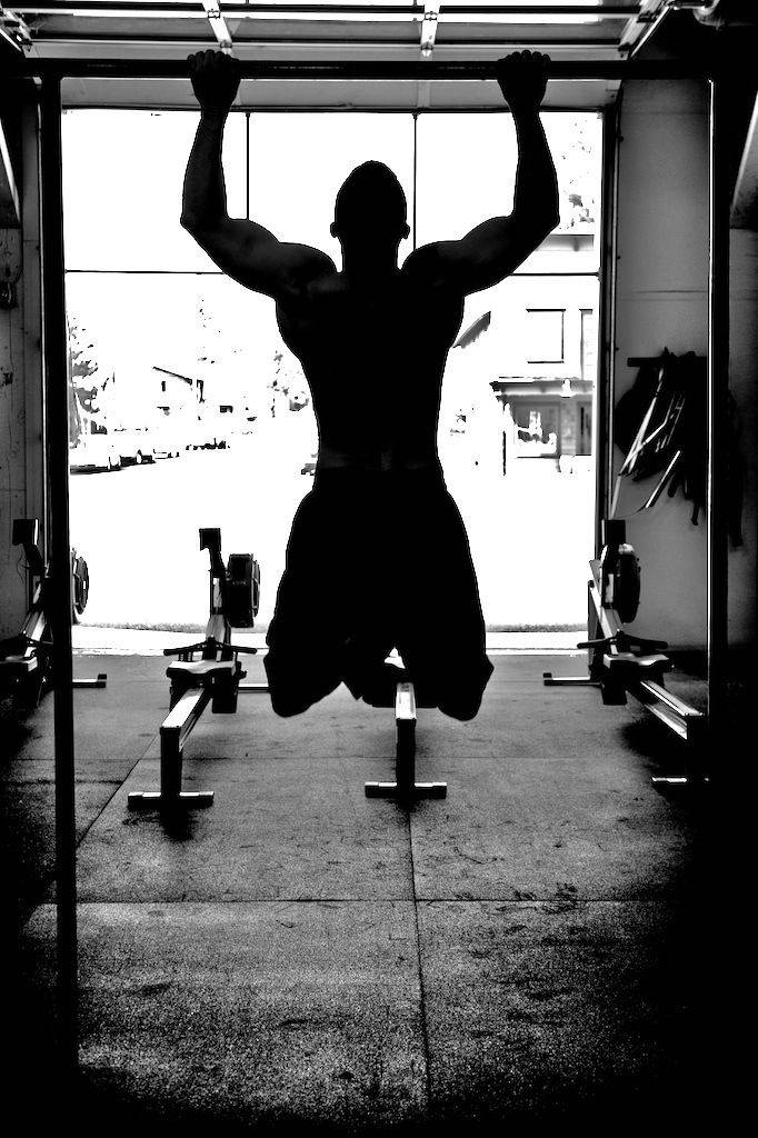 Man Doing Pull-ups At Gym Wallpaper