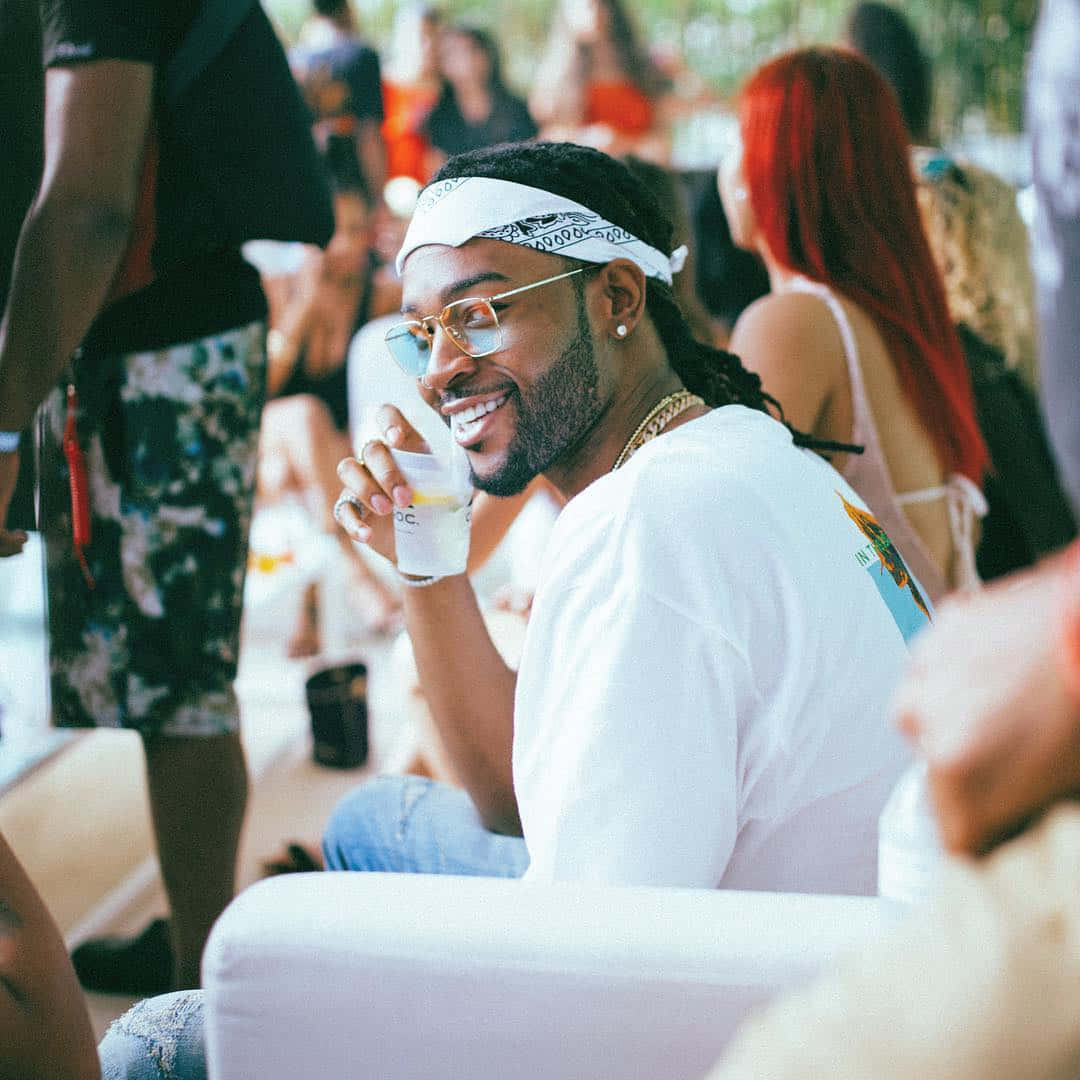 Man Enjoying Outdoor Party Smiling With Drink Wallpaper